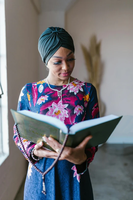 a woman with a turban reading a book