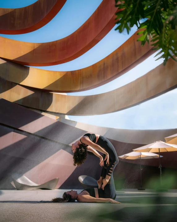 two people kneeling on the ground in front of some curved metal structures