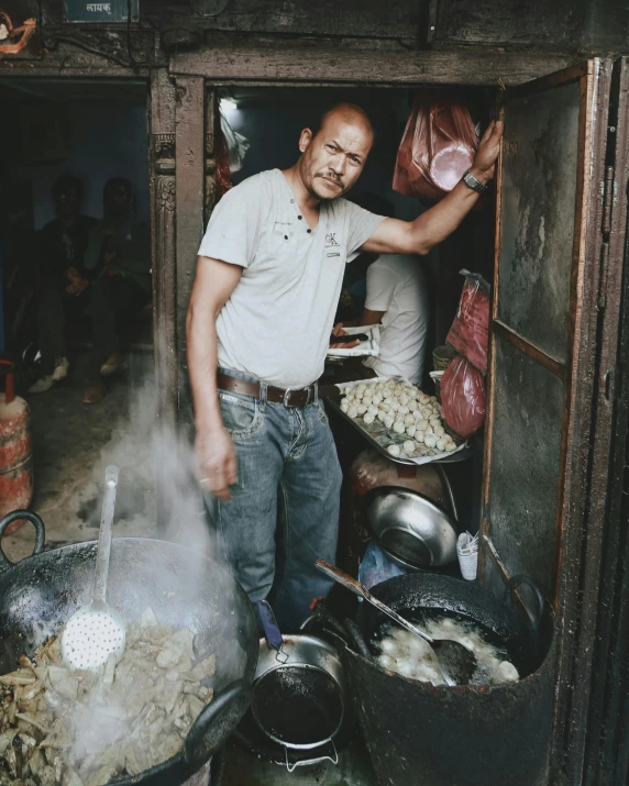 a man standing in front of a big wooden kitchen filled with food