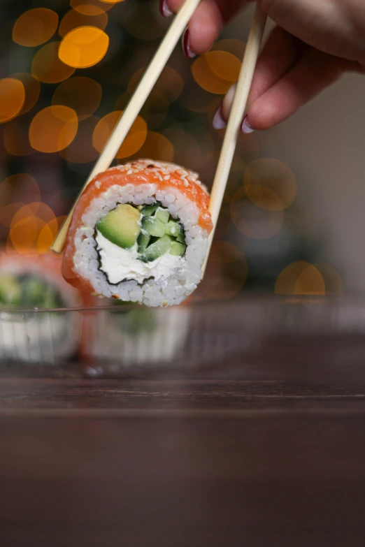 sushi on the table in front of a blurred christmas tree