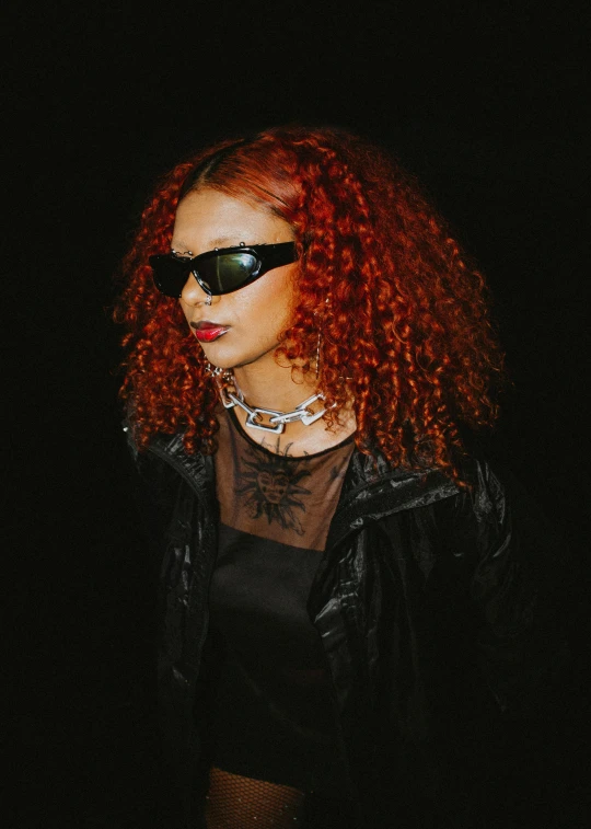 a woman with red hair wearing sunglasses and a leather jacket
