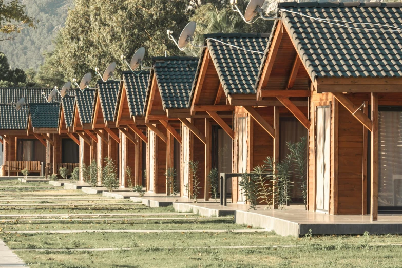 rows of tiny houses with wooden shingles in a yard