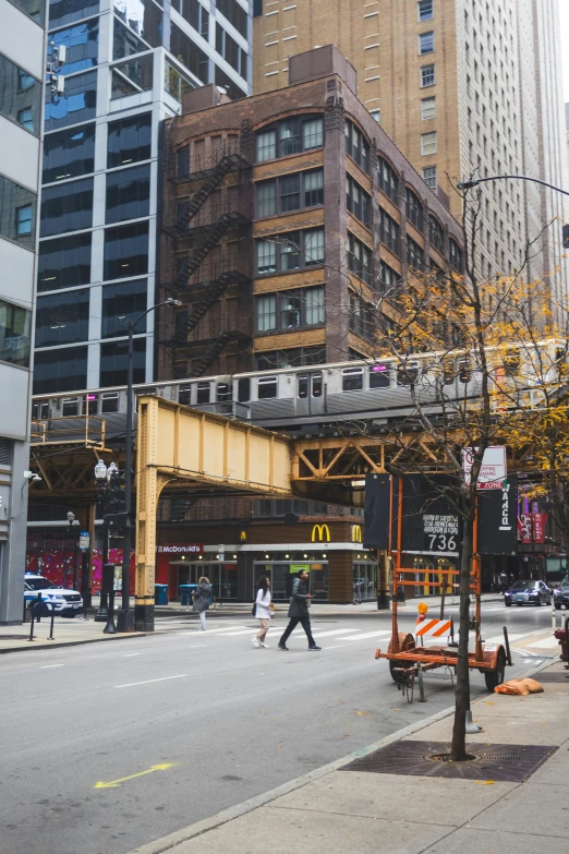 a city street with cars and a train on the tracks