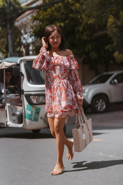 a woman is walking down the street in a dress