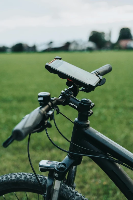 a phone holder is attached to the handle bar of a bicycle