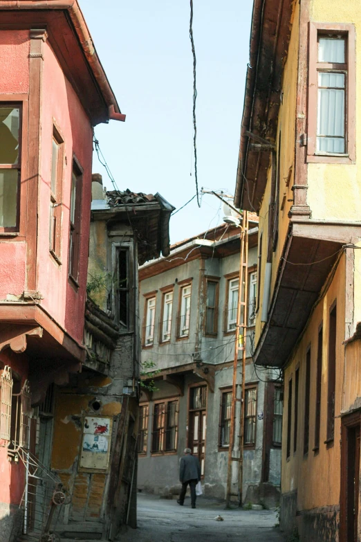 a person walks down a narrow alleyway between two buildings