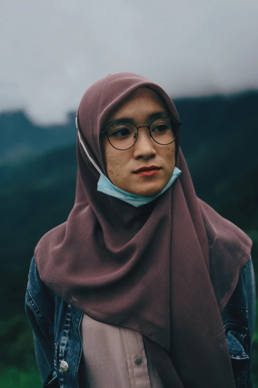 the young woman wearing glasses is wearing a shawl