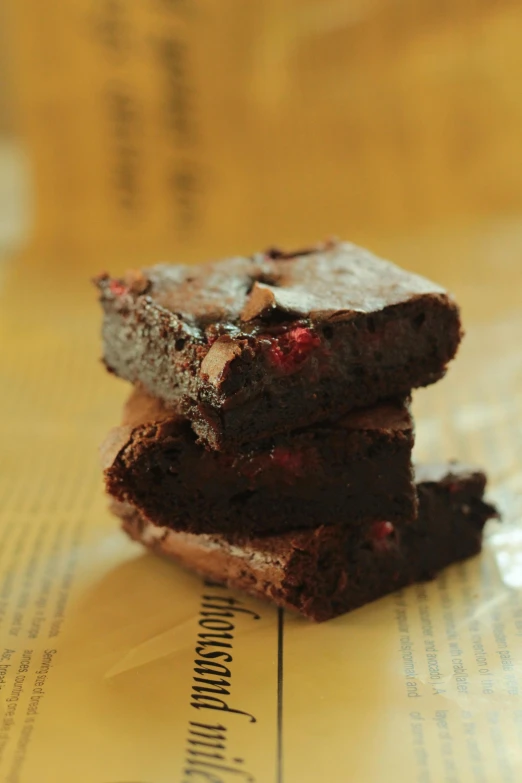 three brownies stacked on top of each other, sitting on paper