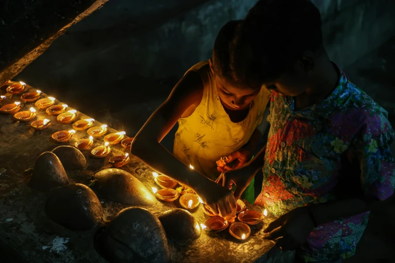 a couple of people that are lighting some candles