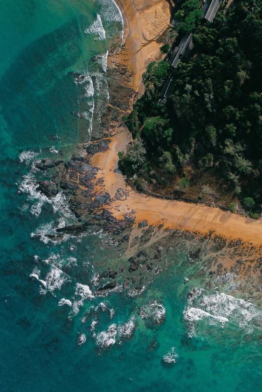 an aerial view of a road beside the ocean