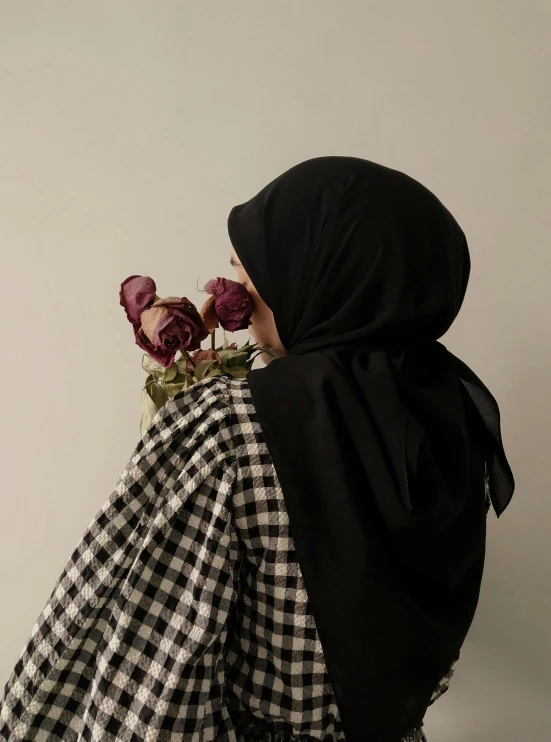 a woman with a black robe and a checkered tablecloth on her back