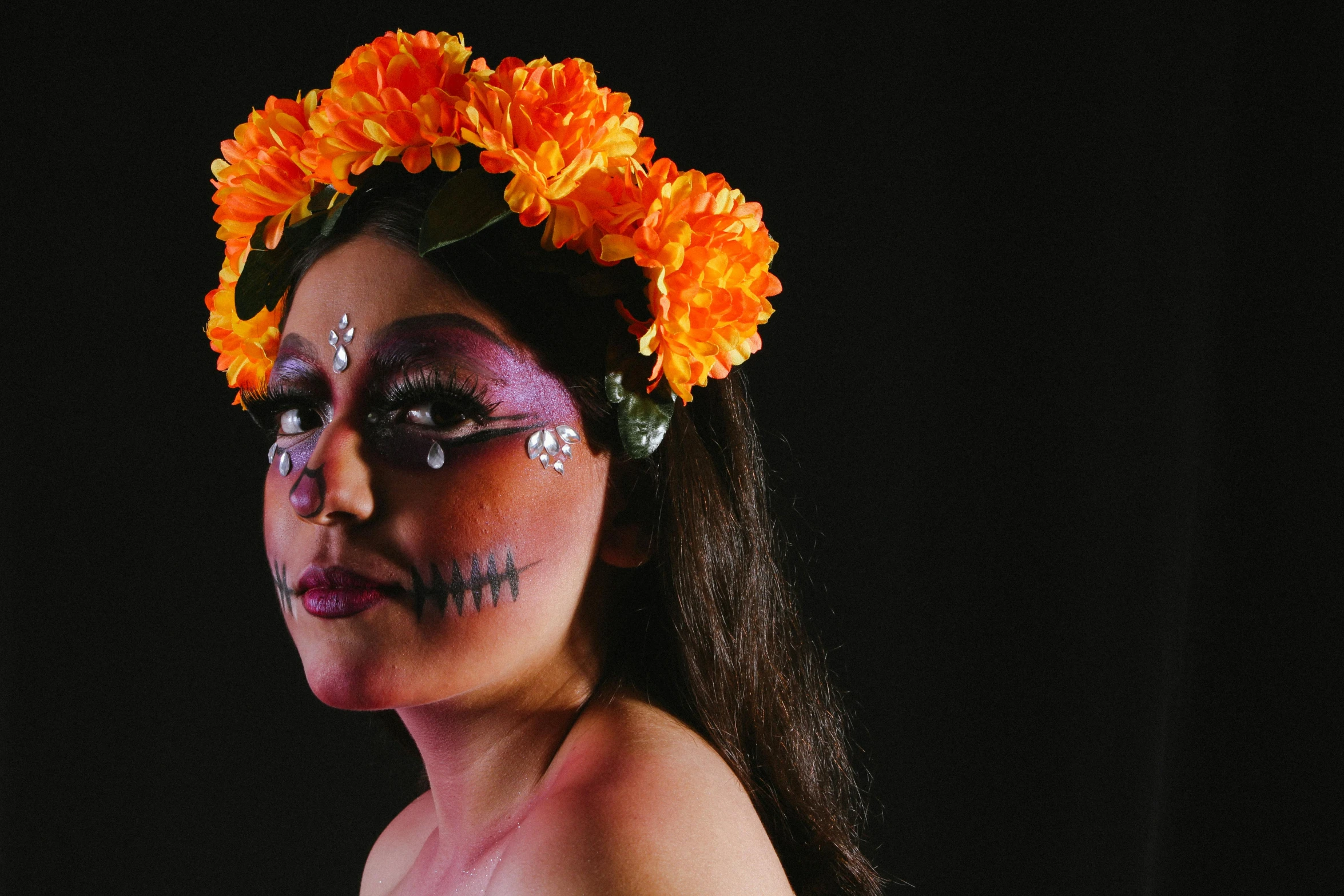 a woman with makeup, flowers in her hair and a headband