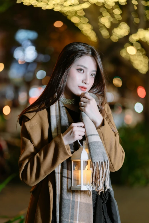 a woman in winter clothing holding up a lantern