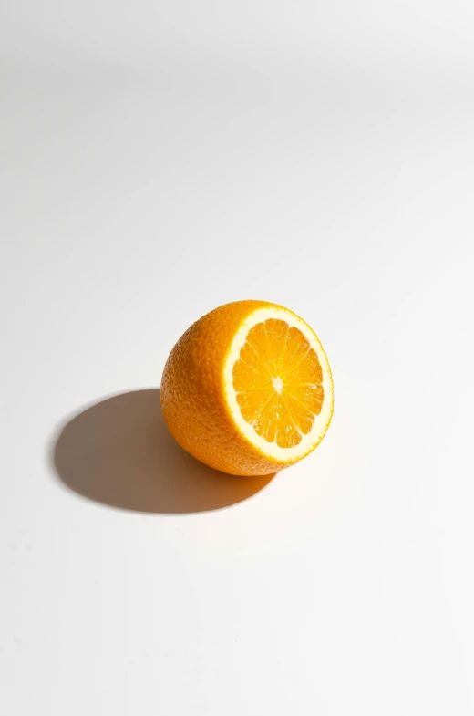 an orange sitting in a white table with one half cut open