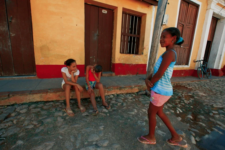 three girls on the street talking to one another