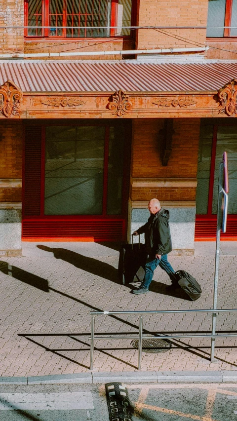 a man walks on a city street next to a building