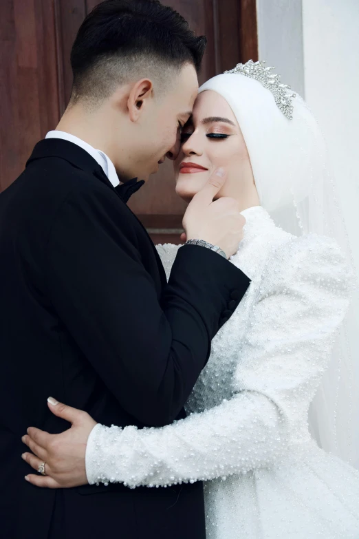 a bride and groom standing together in front of a door