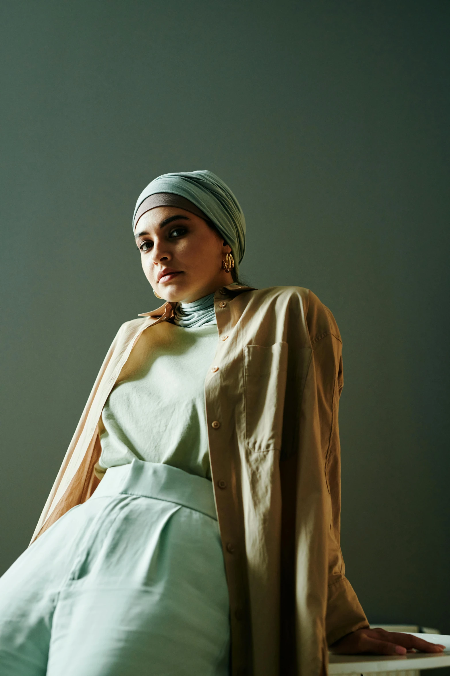 woman in long dress sitting on a chair with a scarf around her neck