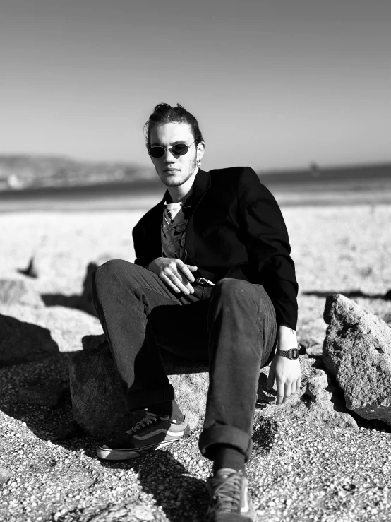 a man sitting on rocks in the sand