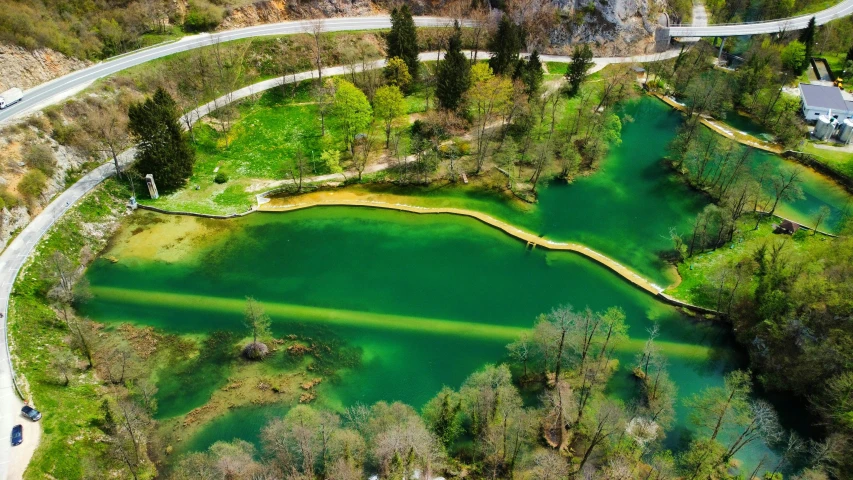 a winding road is next to a large pond