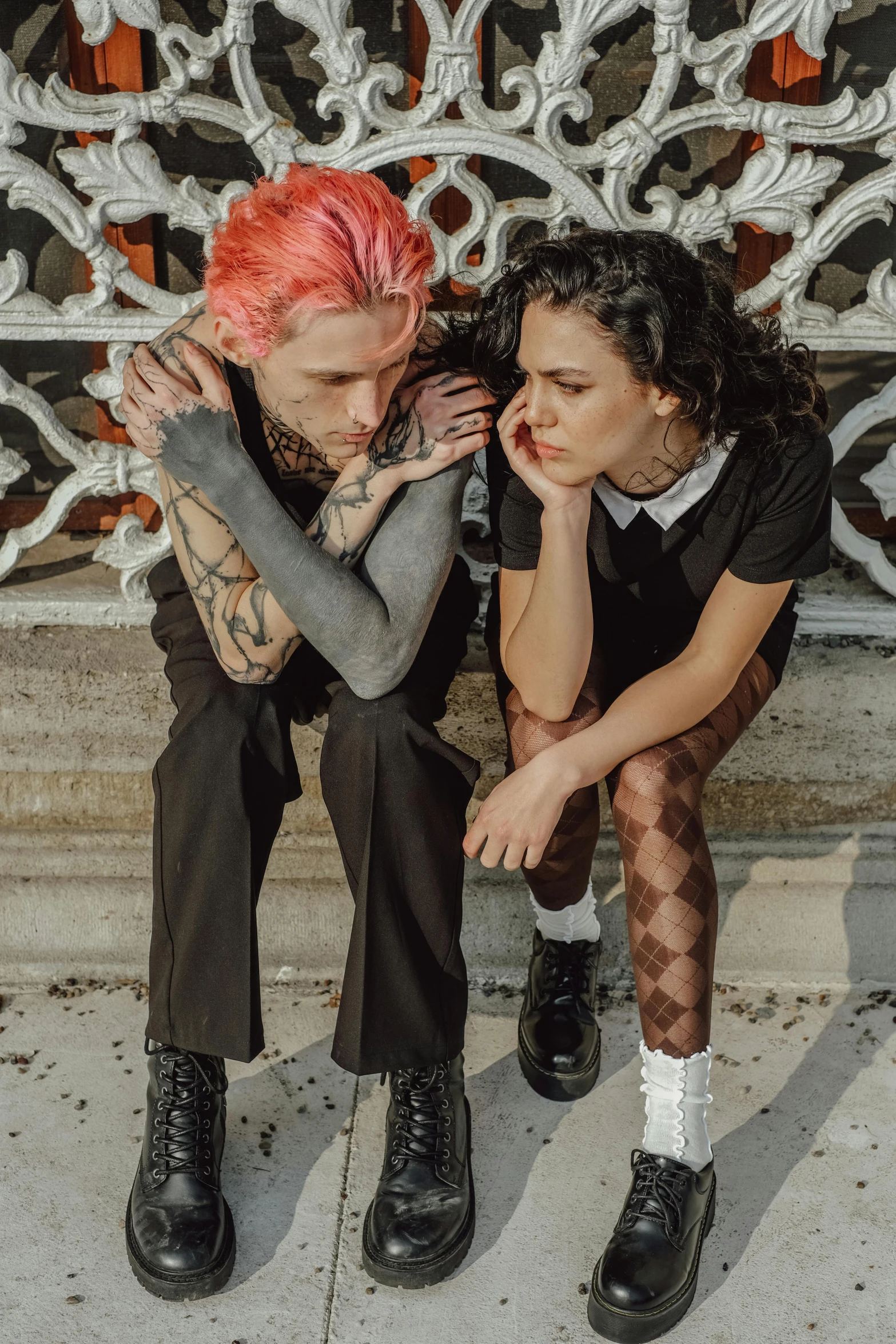 two women and a man sitting outside near each other