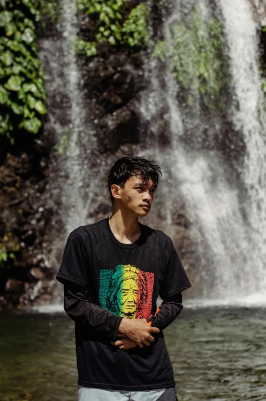 a man standing in front of a waterfall