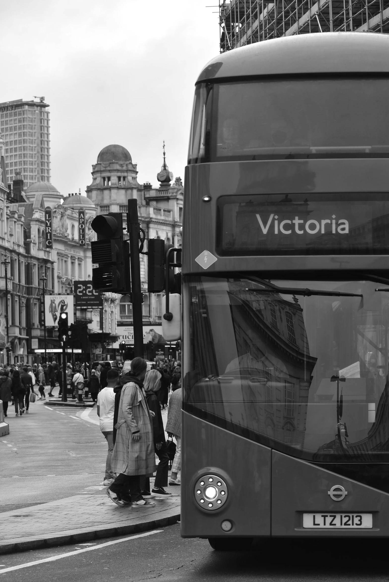 two people walking near an open top bus