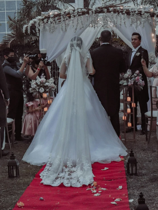 a couple that is standing under a wedding archway