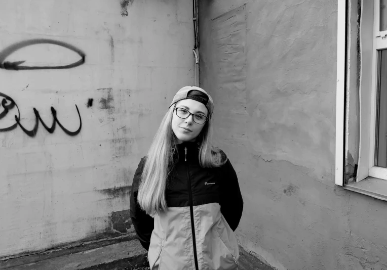 a woman in glasses is standing outside in a black and white po