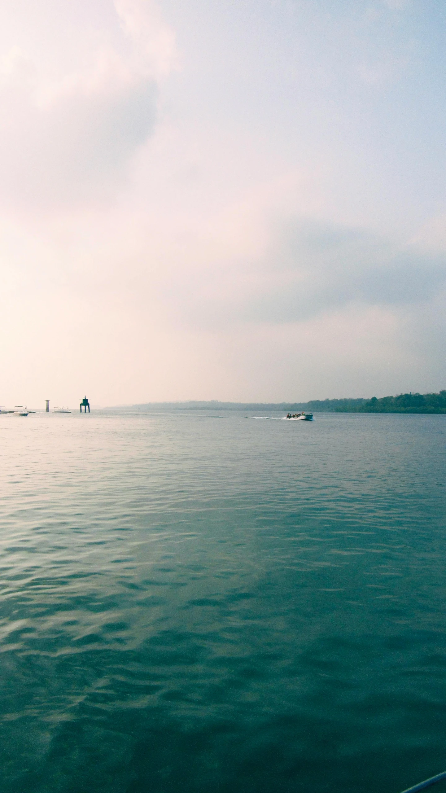 the sky is very cloudy as the boats can be seen out on the water