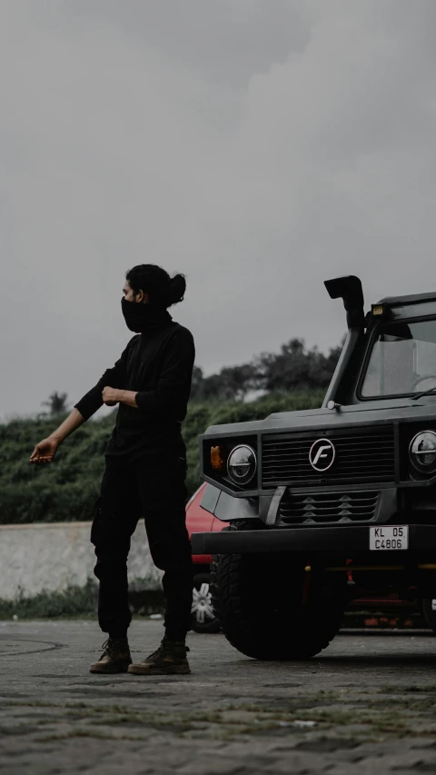 a person wearing a mask next to a vehicle