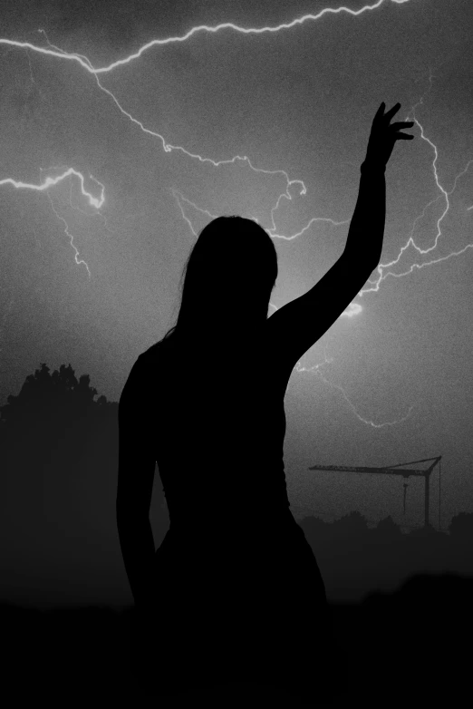 black and white po of a woman in front of a dark sky with lightning