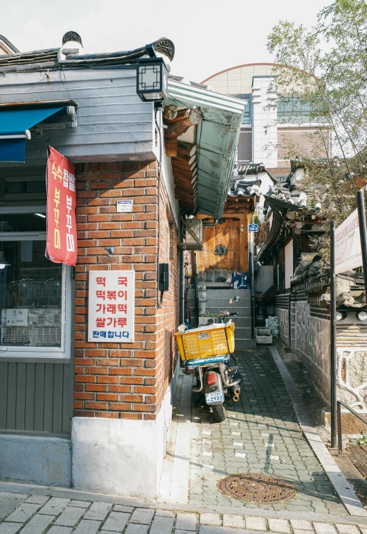 a small street in an asian city with people on their bikes