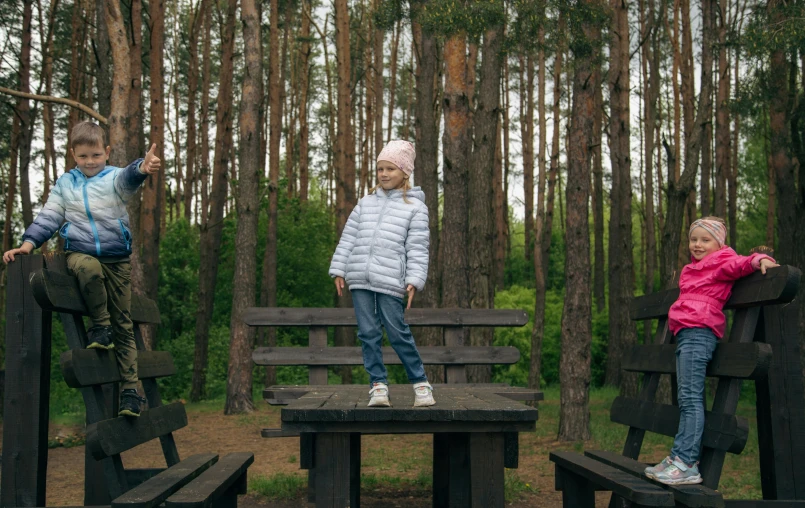 two s are sitting on a bench in the woods