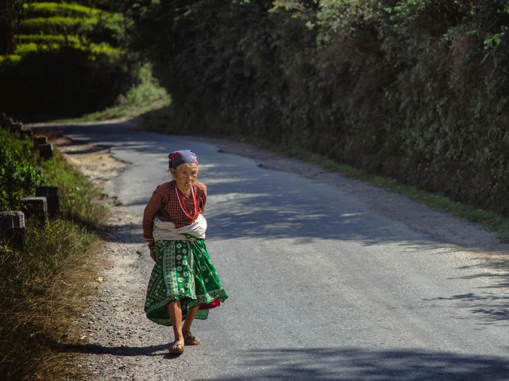 a woman walking down the middle of a road