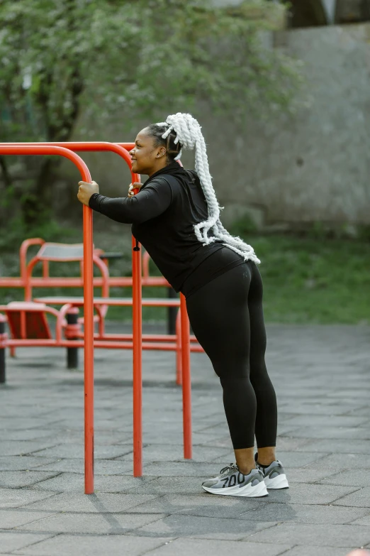 a woman is standing behind a colorful play structure