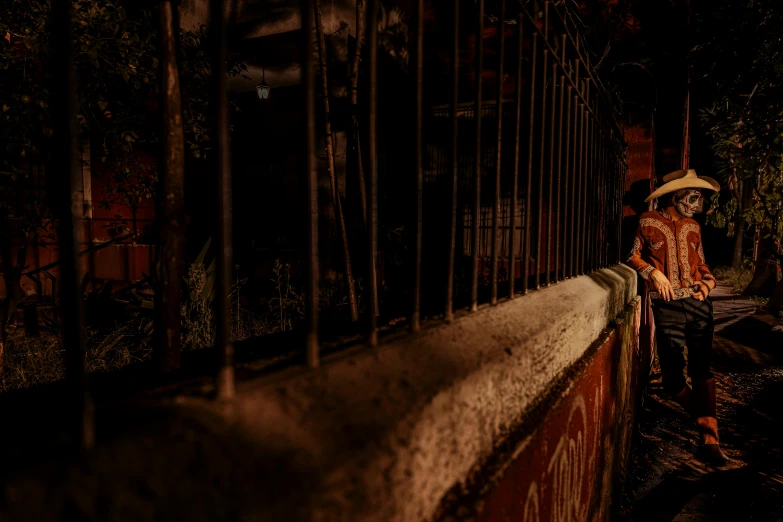 a woman sitting on a fence at night in a very dark setting