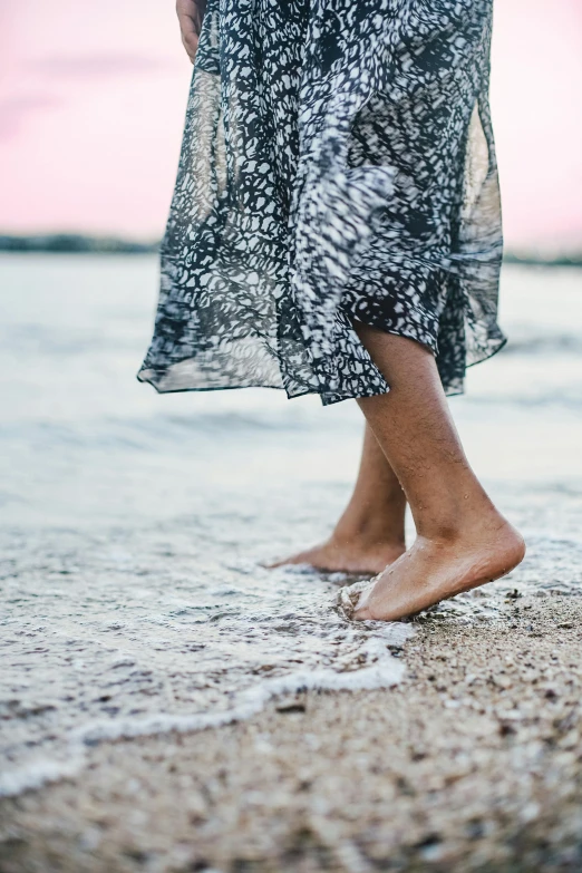 a person walking on top of a sandy beach