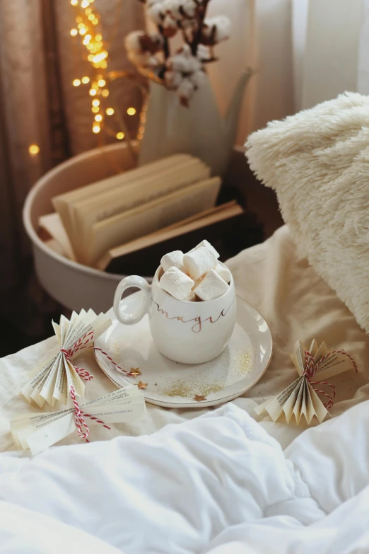 a tea cup and saucer with a gift card in front of it on a blanket