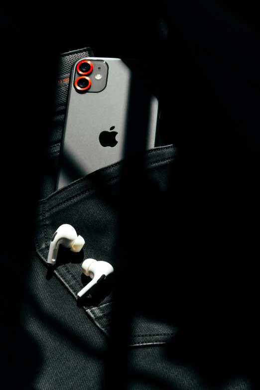 an iphone in a cellphone pocket that has ear buds