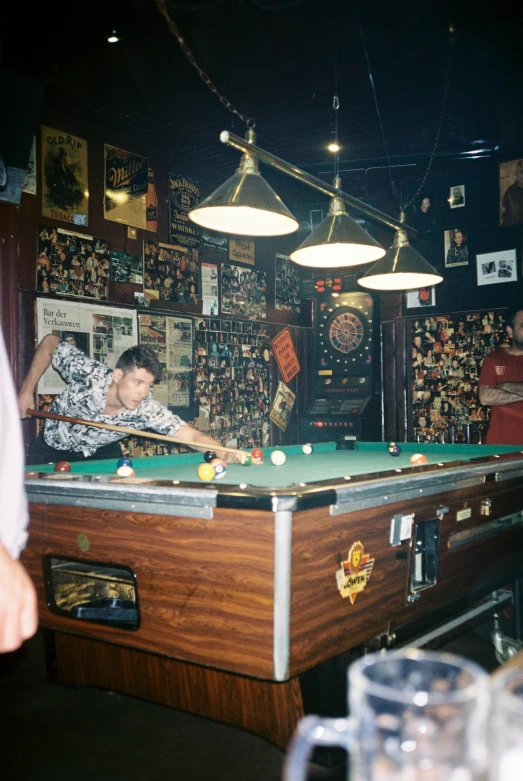 man standing at pool table with many games on display