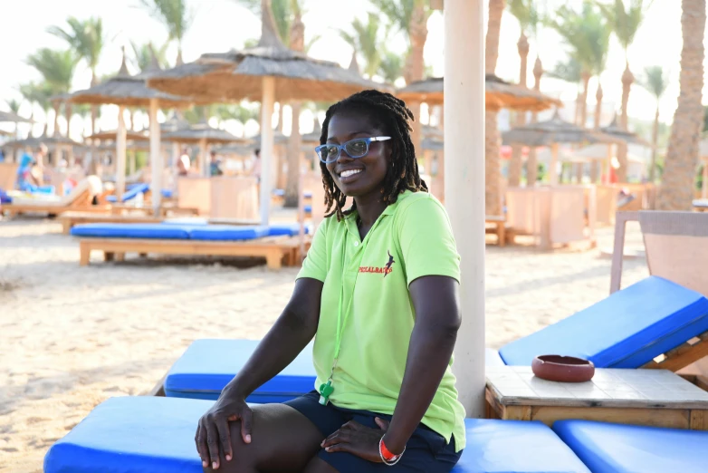 the woman in green is sitting on some beach lounges