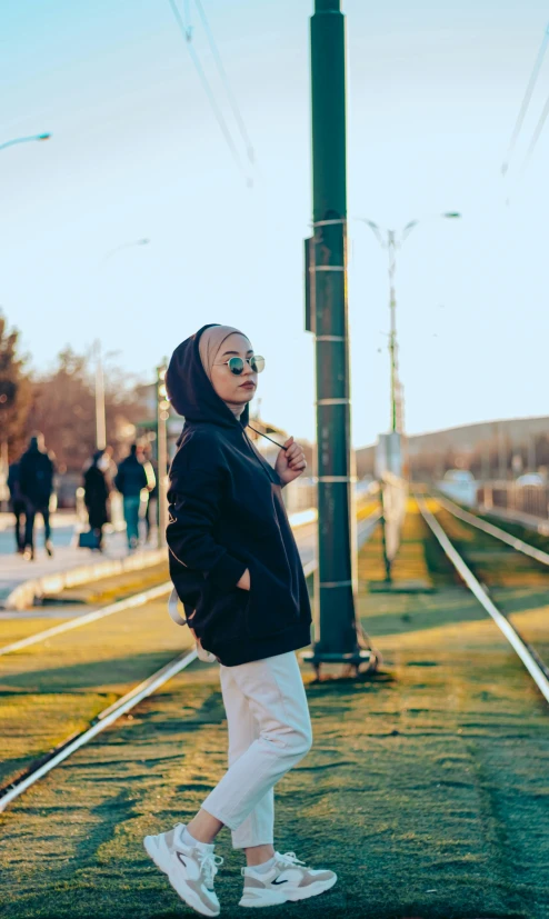 a woman walking down the train tracks