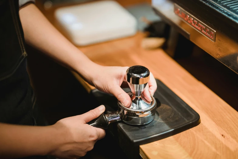 someone turning the top on their coffee grinder