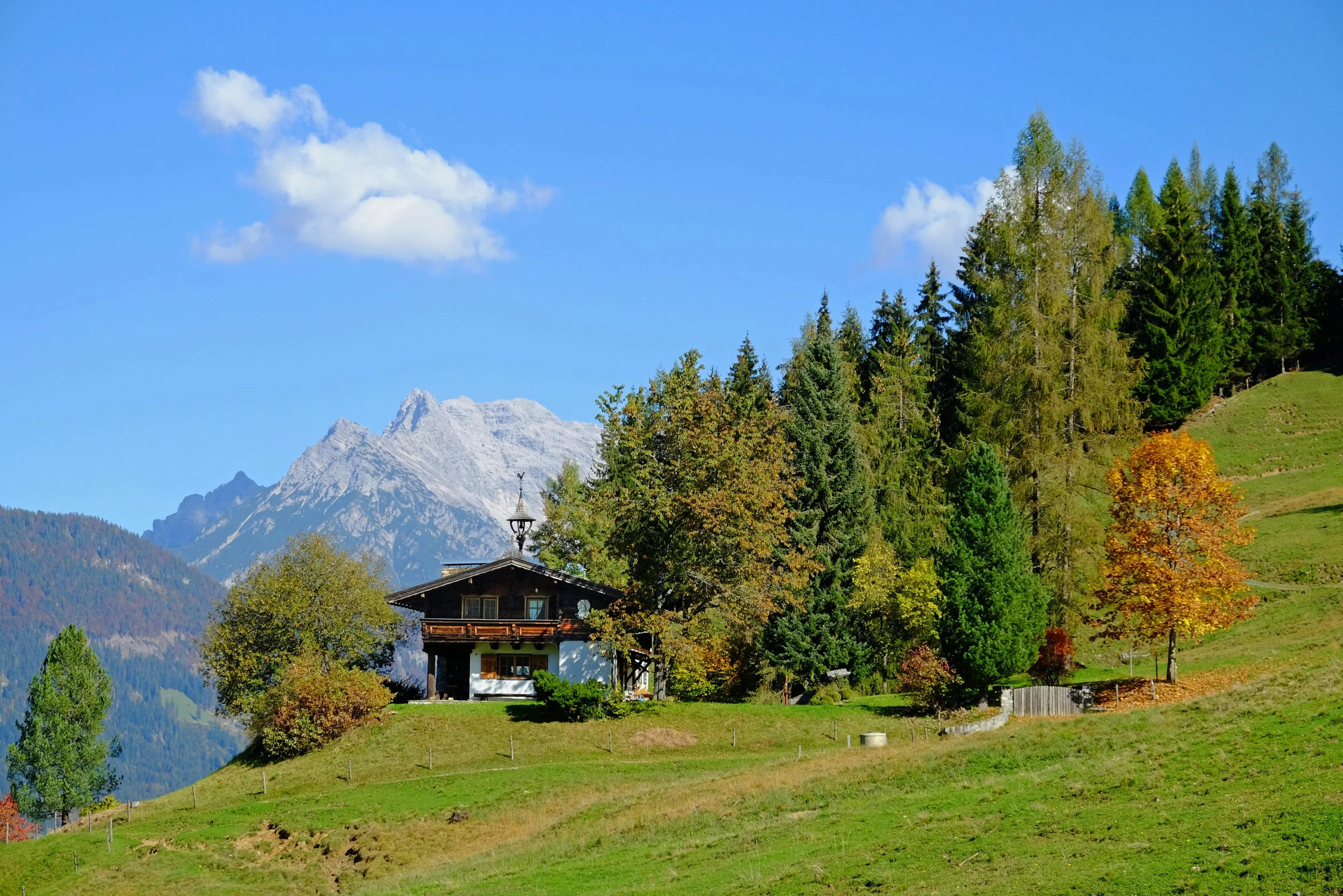 a small wooden house on a grassy hill