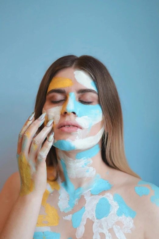 a young woman with her face painted in white and blue