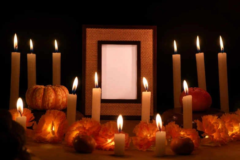 a large group of lit candles with some pumpkins