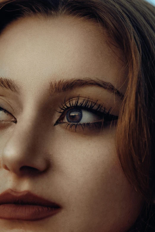 a female with a brown hair and a blue eyed look