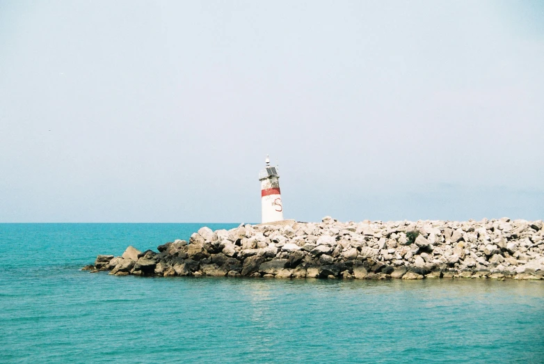 an image of a small lighthouse in the middle of a sea