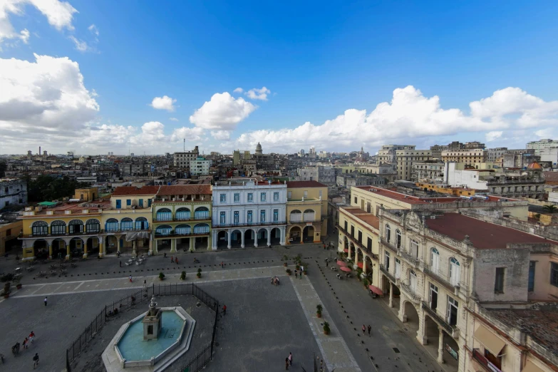 city square with clock tower with several buildings in the background